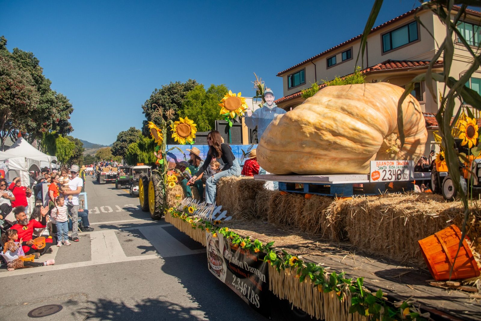 A giant pumpkin on a parade float at the Half Moon Bay Art and Pumpkin Festival