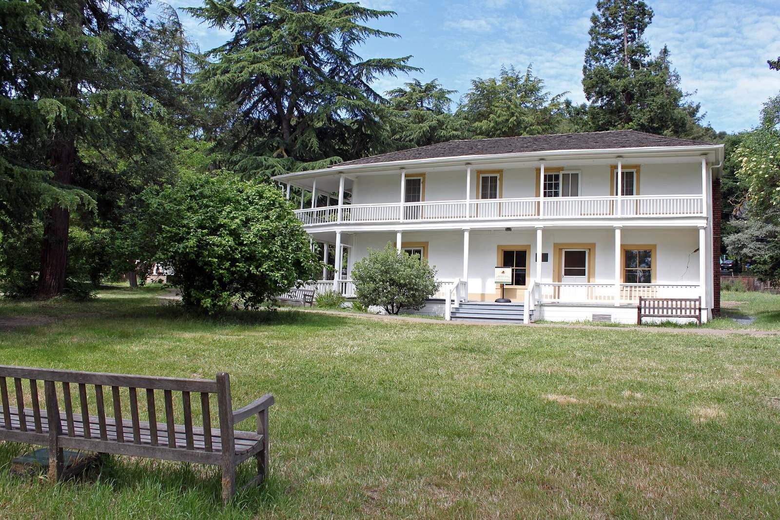 The two-story Martinez Adobe with a wide porch and balcony