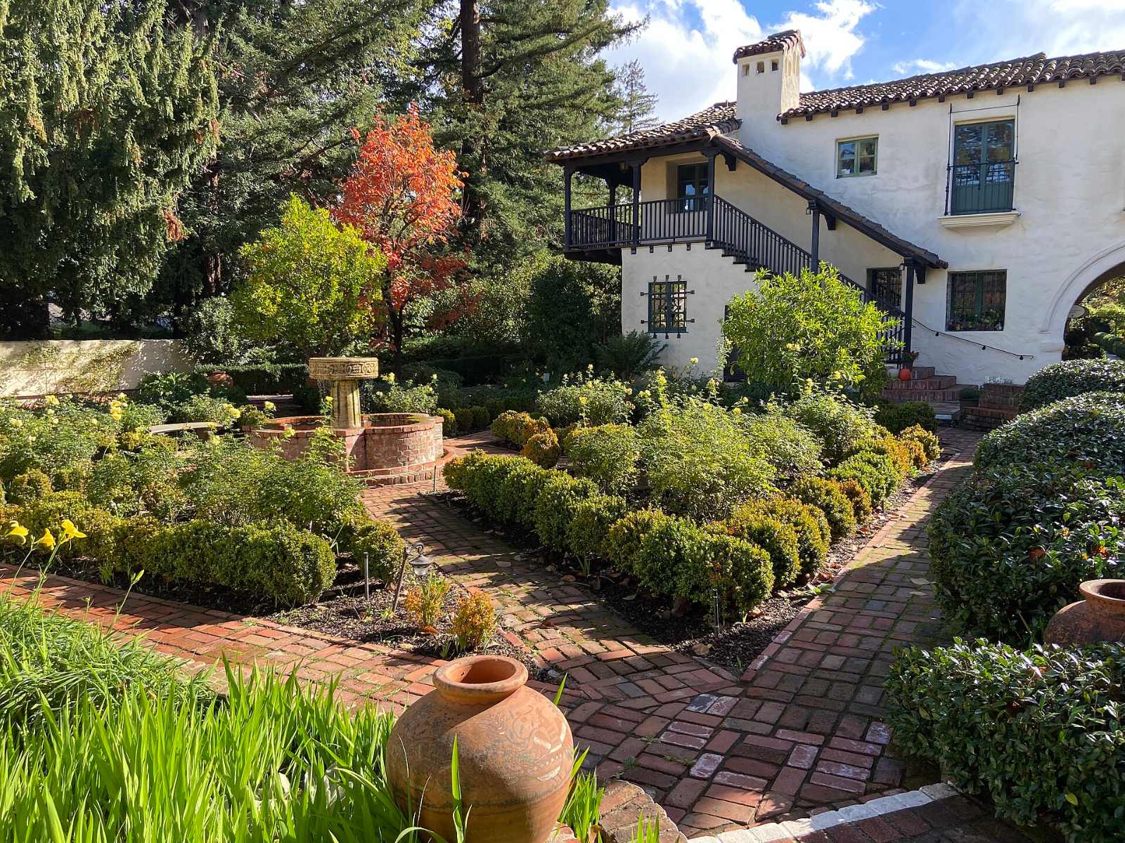 A garden courtyard with white walls and tiled roofs at the Allied Arts Guild
