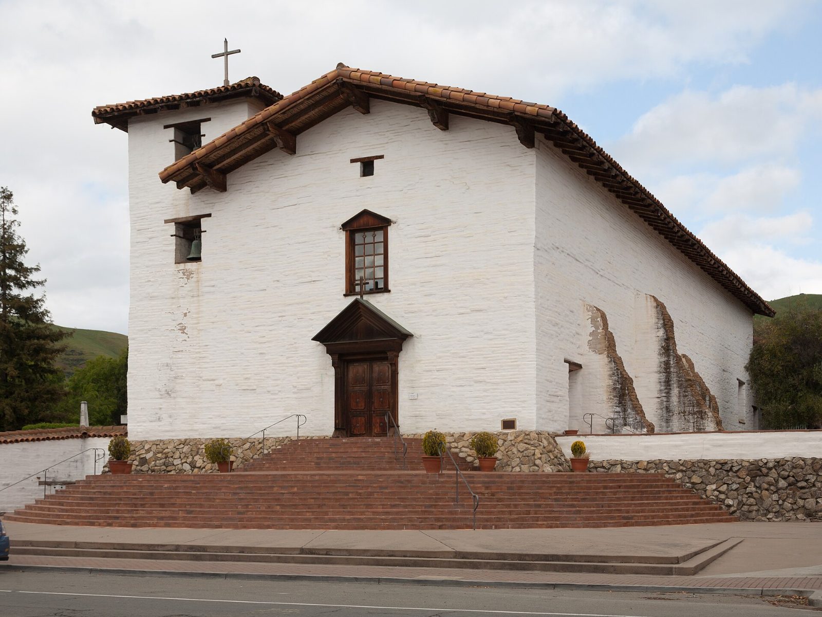 The white adobe church of Mission San José with its red tile roof