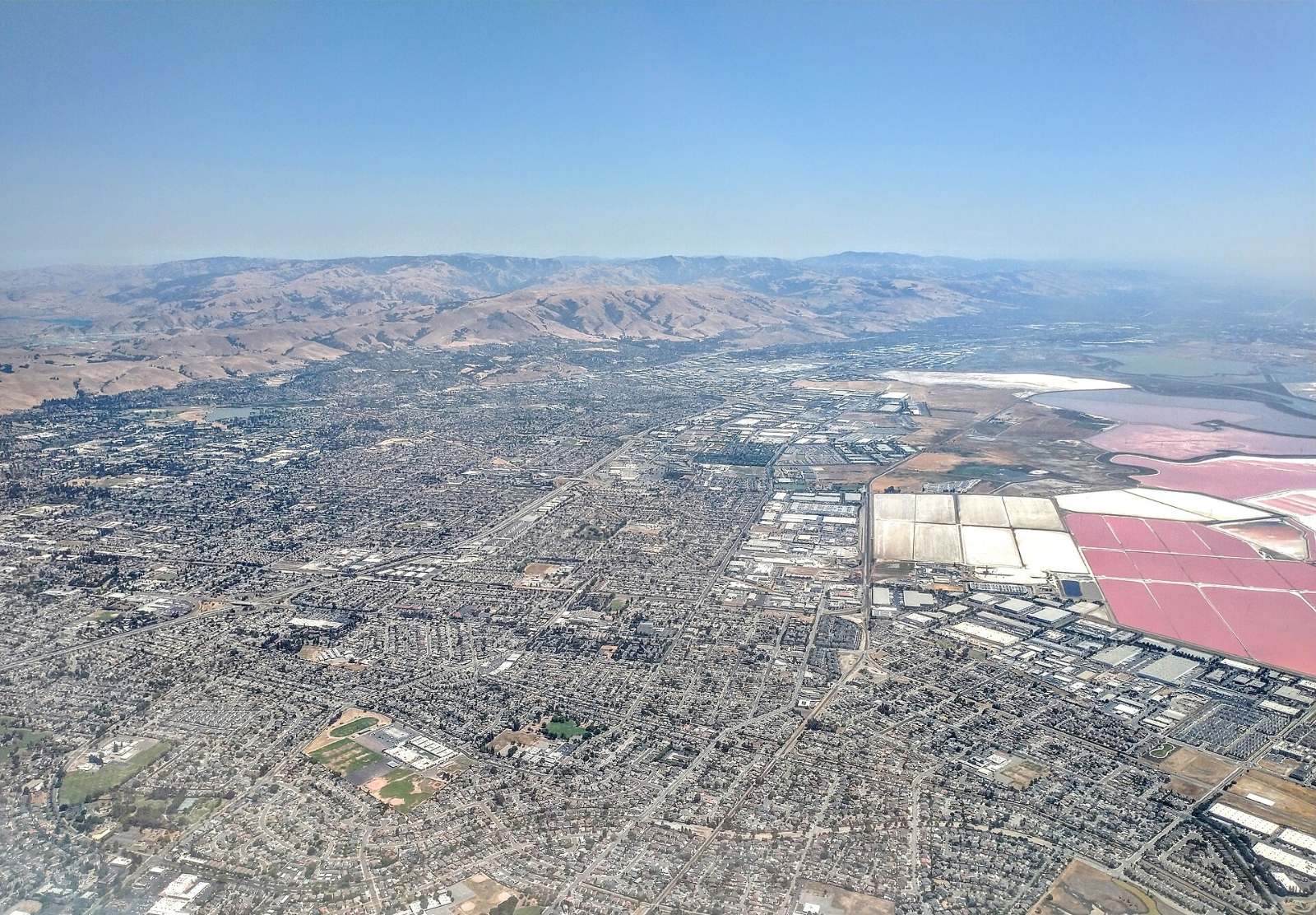 Aerial view of Newark and Fremont with colorful salt ponds along the bay