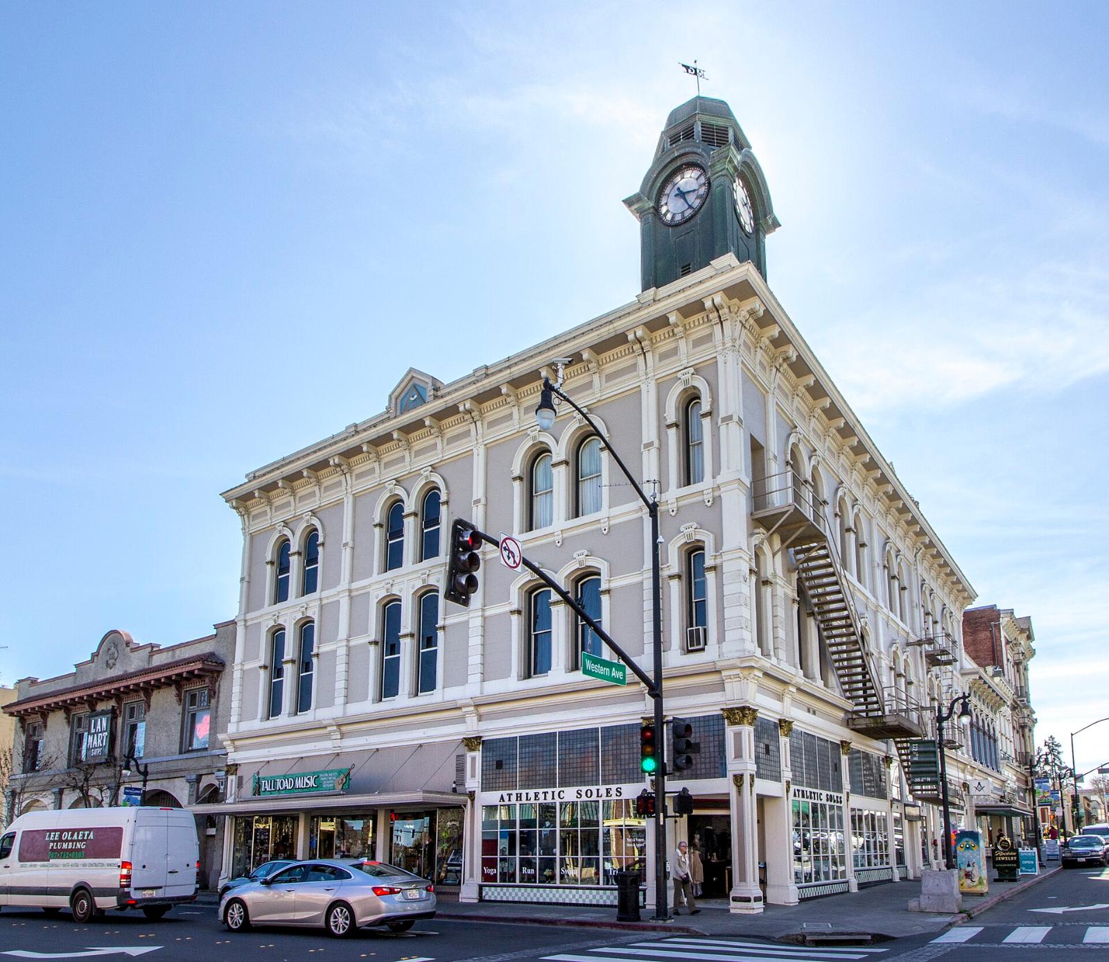 A historic downtown Petaluma building with a clock tower on a street corner