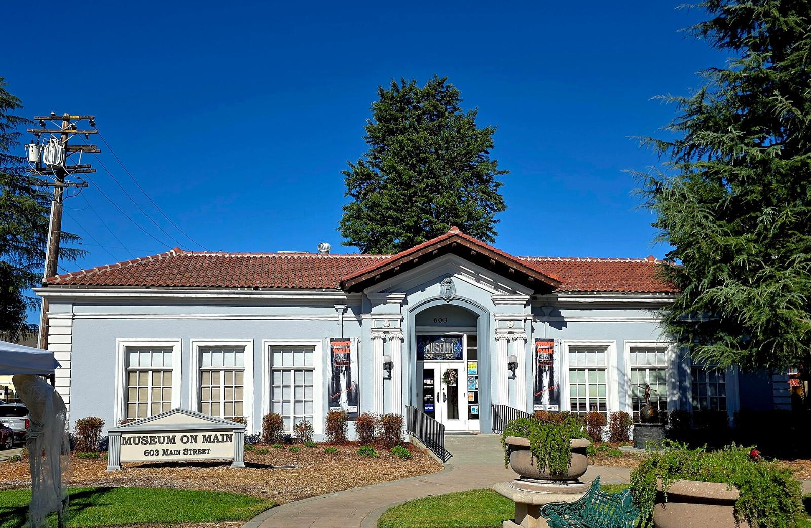 The Museum on Main, a white building with a red tile roof on Pleasanton’s Main Street