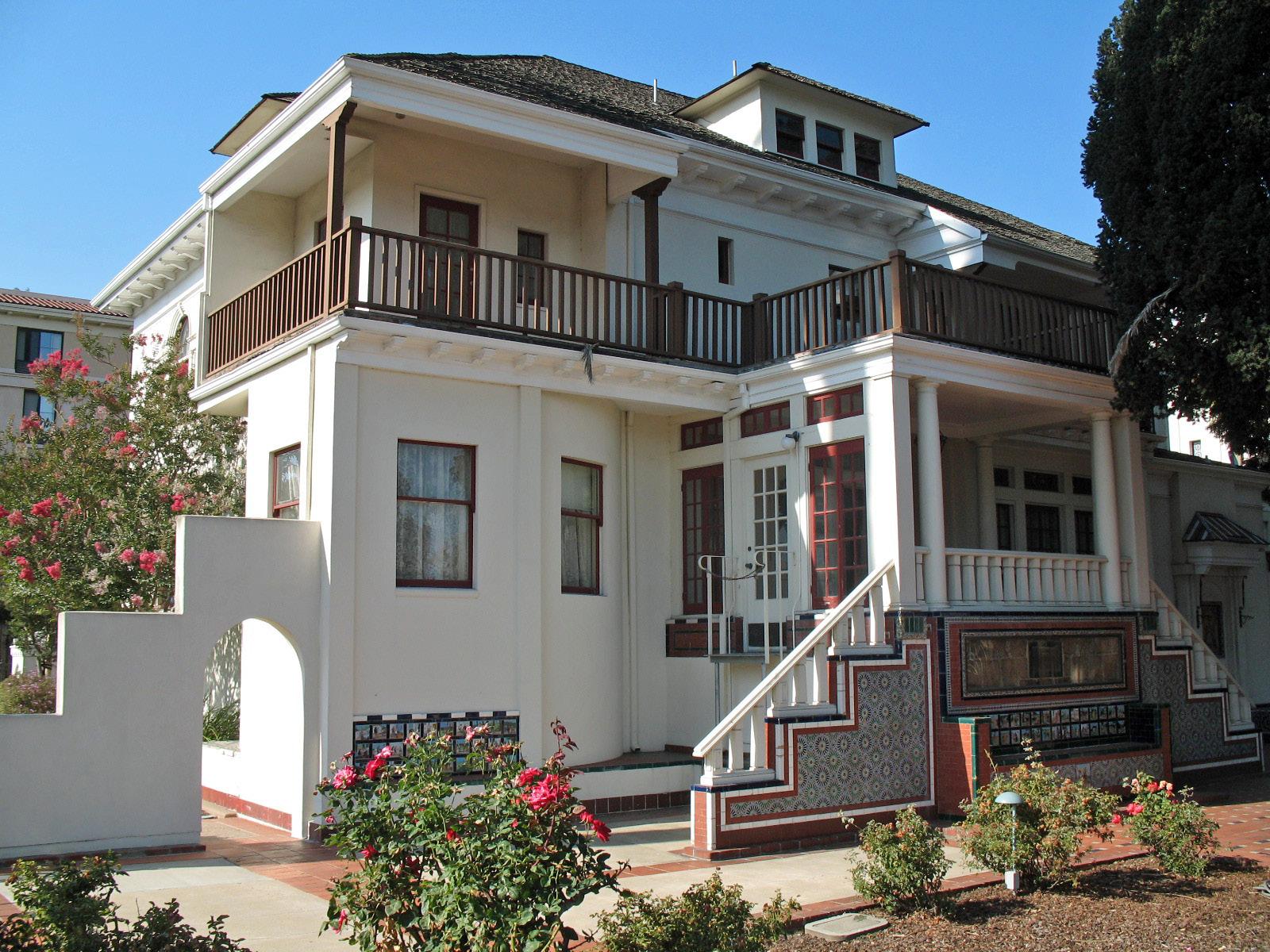 Casa Peralta, a white two-story house with Spanish details and a front garden