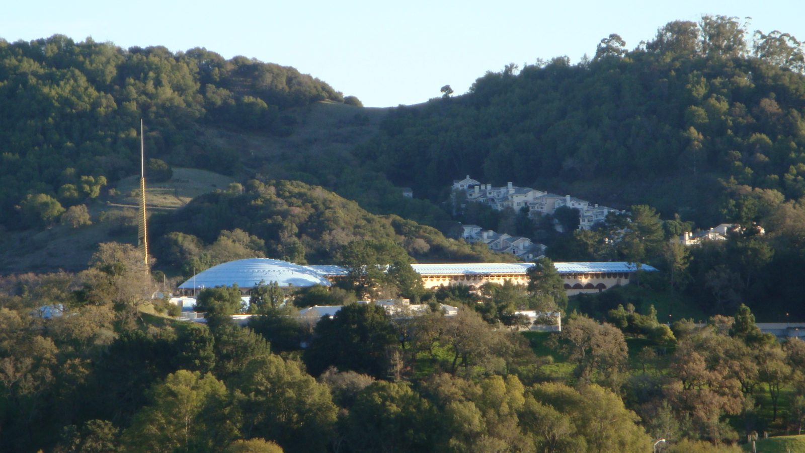 The long, arched buildings of the Marin County Civic Center against wooded hills