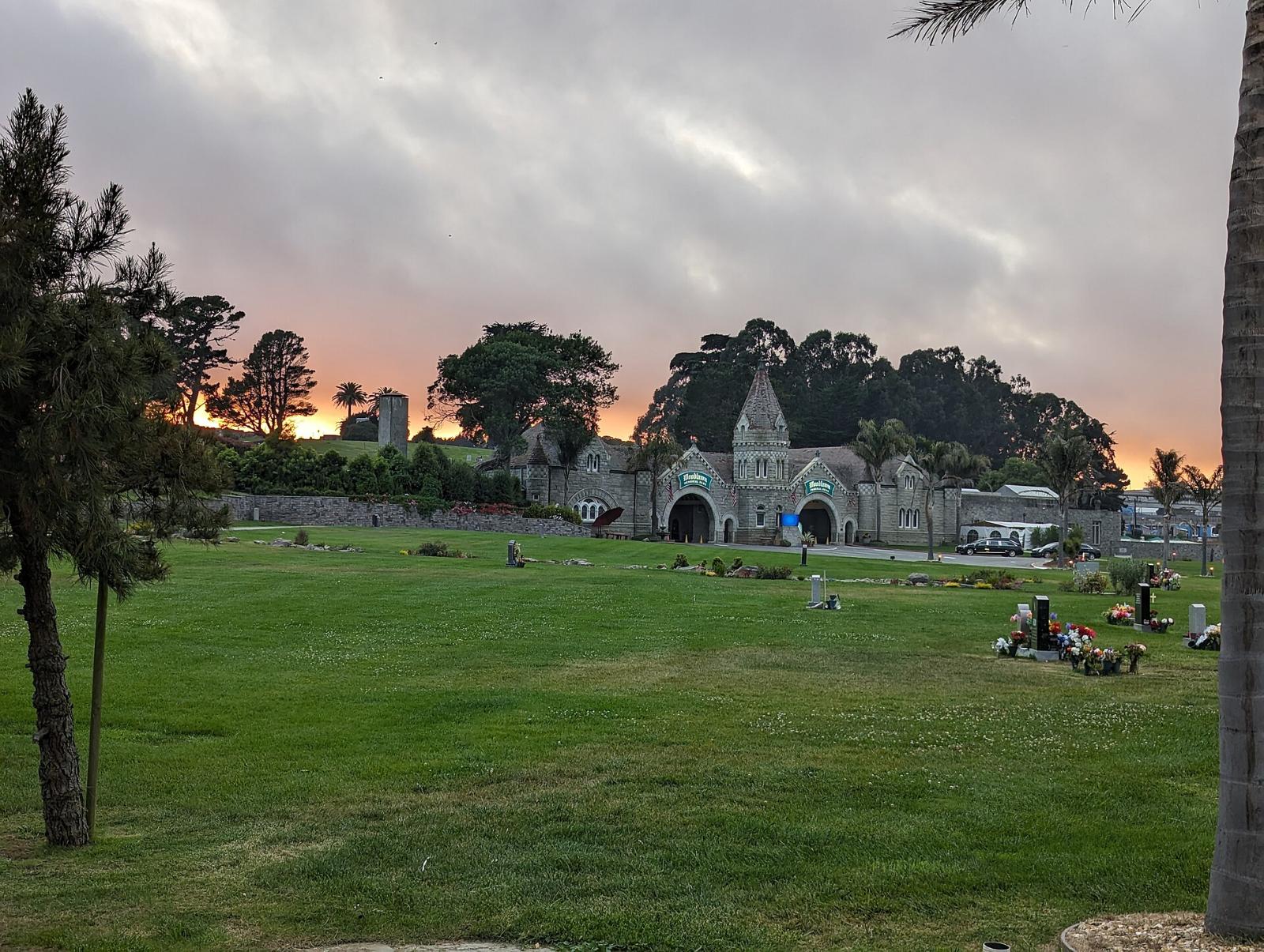 Lawns at Woodlawn Memorial Park in Colma at sunset, with the chapel in the distance